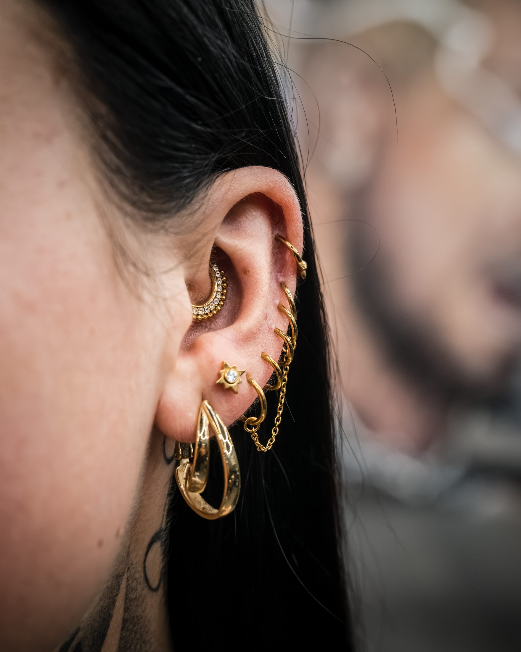 Mehrere gut verheilte Ohrpiercings mit goldenem Schmuck